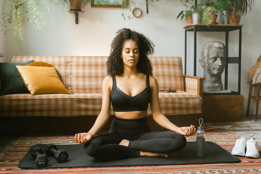 Woman meditating on mat in calm, serene mood)